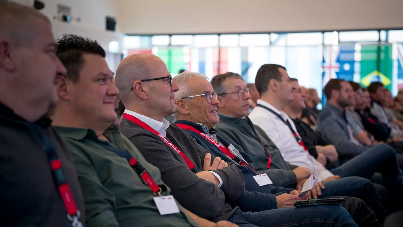 Partner sitzen in einer Reihe und sehen sich die Vortraege des Events an