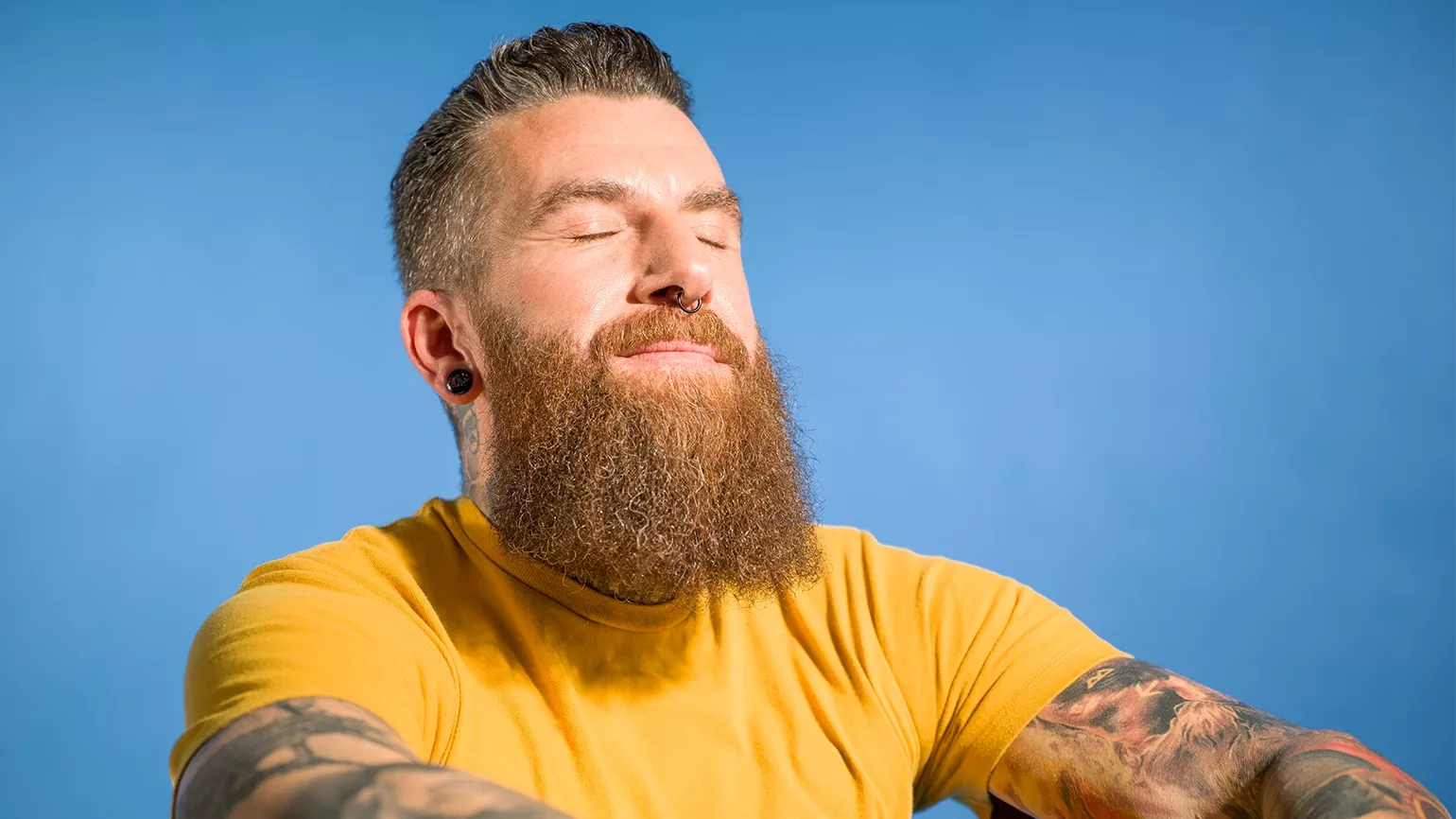 Männliche Person dreht Kopf mit geschlossenen Augen in Richtung Sonne