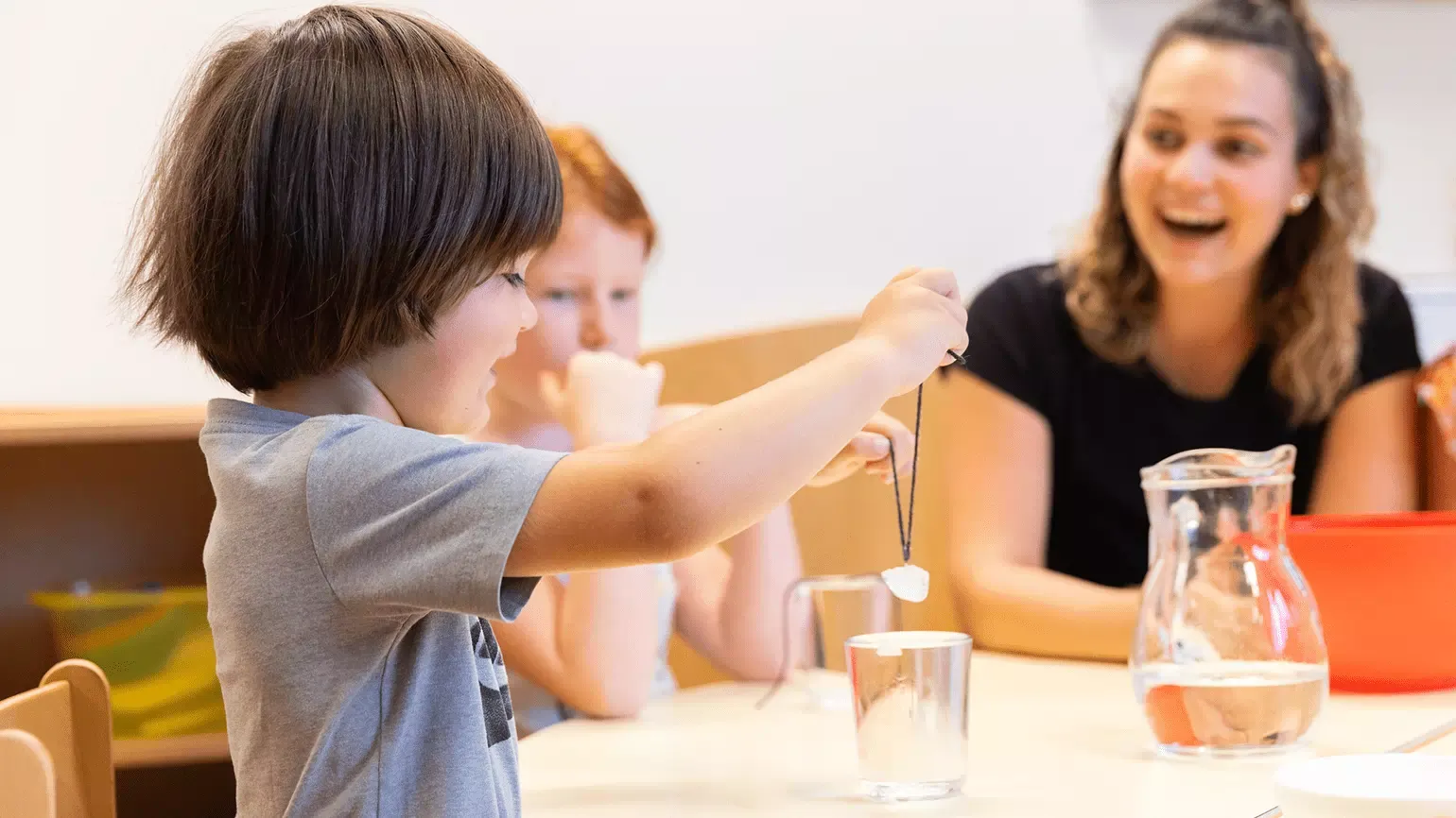 Junge beim Kristallexperiment mit Wasser und Salz