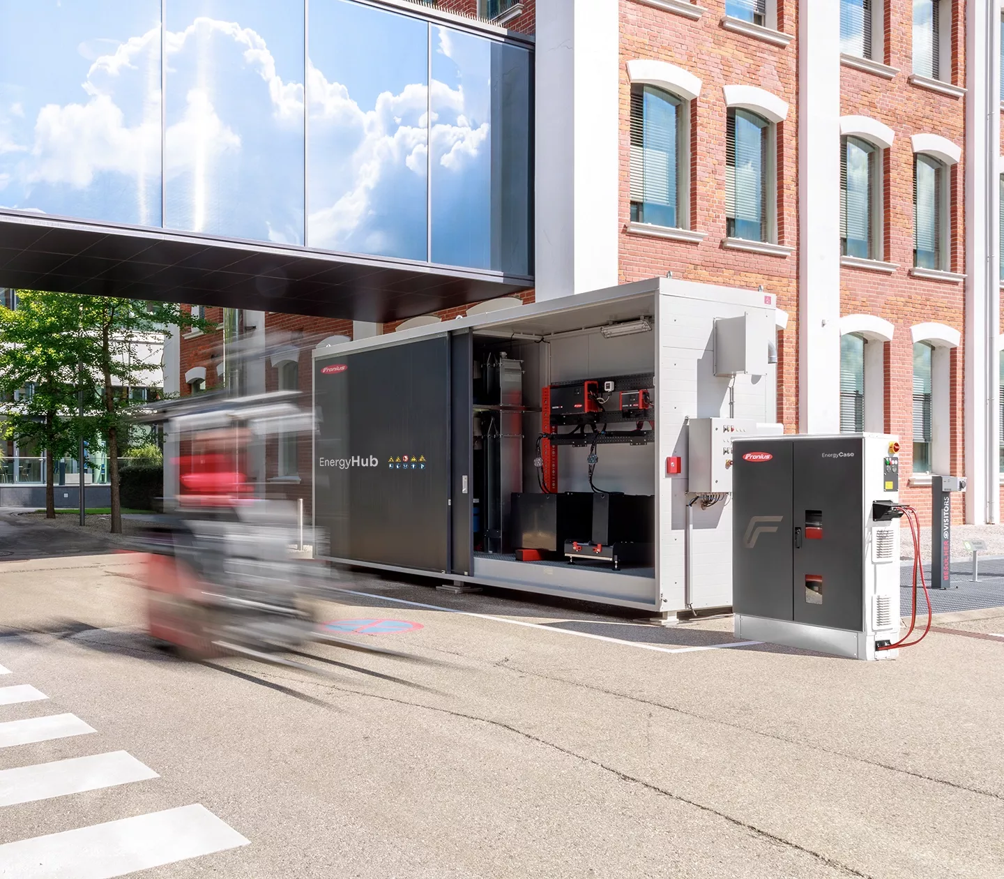 Fronius EnergyHub und EnergyCase vor einem Backsteingebäude.