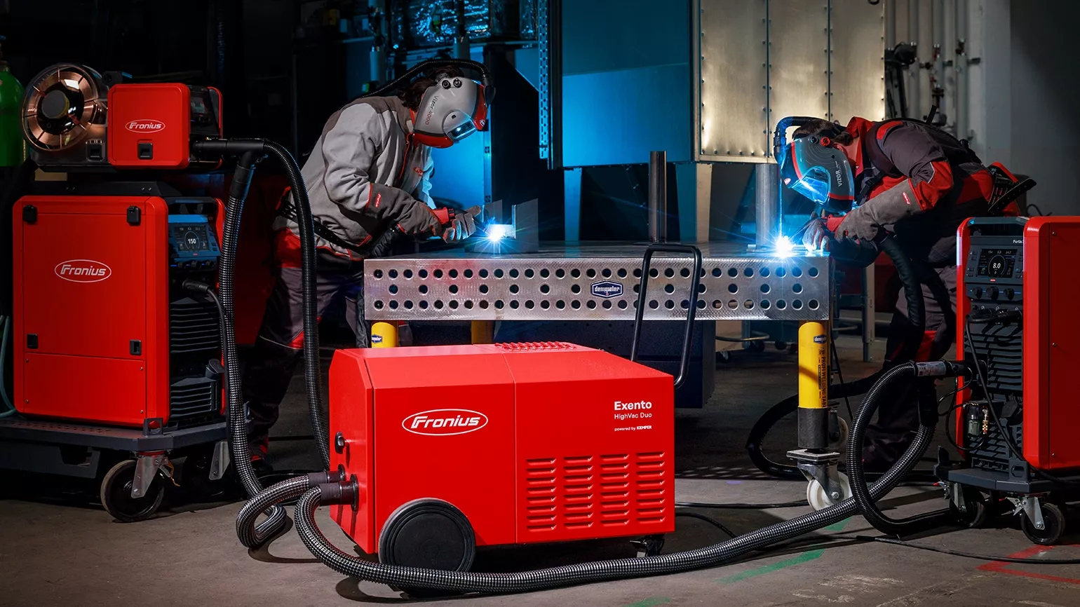 2 männliche Personen gekleidet in Fronius Schweißschutz-Ausrüstung arbeiten mit dem Exento HighVac Duo.