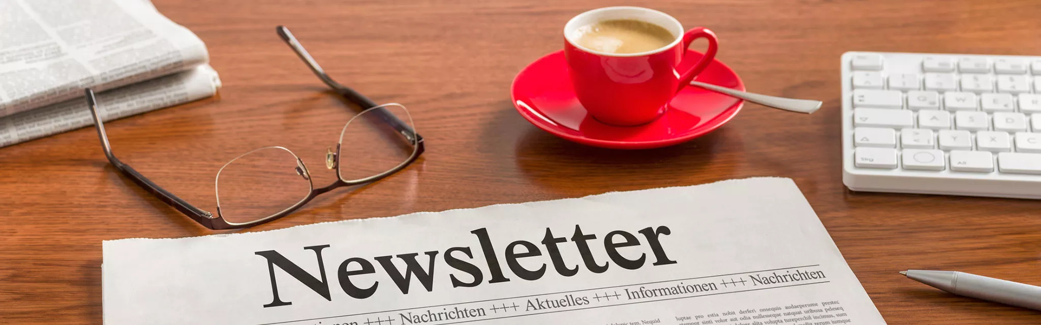 Caffee, glasses, keyboard and newsletter
