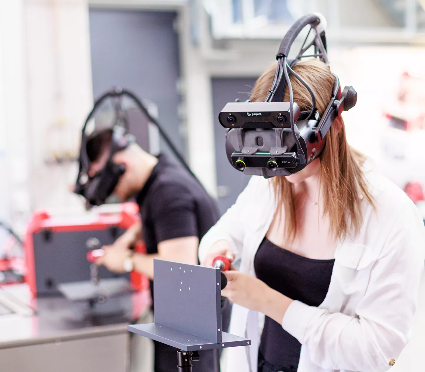 Zwei Personen lernen mit dem Welducation Simulator zu schweißen. 