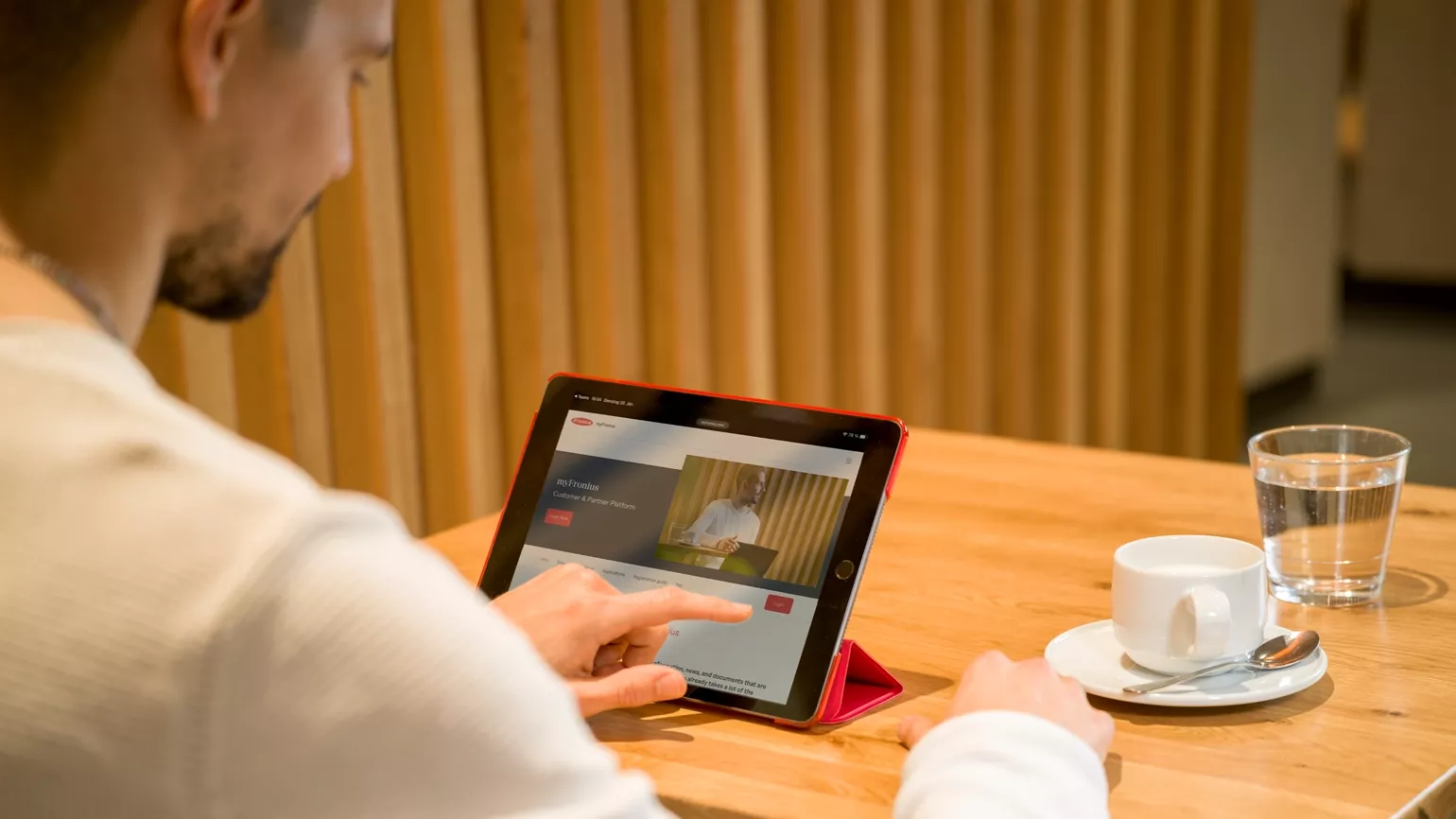Mann scrollt auf Tablet durch myFronius