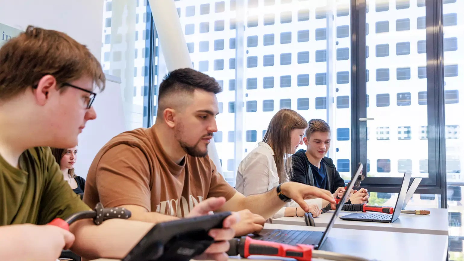 Teenagers sit in front of the laptop and learn