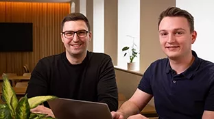 Two Fronius employees smile for the camera.