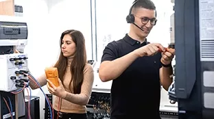 Two Fronius employees working on a Fronius inverter.