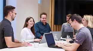 Personengruppe an einem hohen Tisch