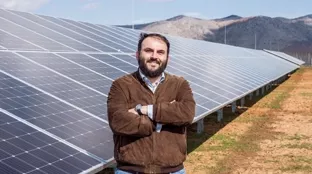 Kunde vor PV-Modulen in Griechenland