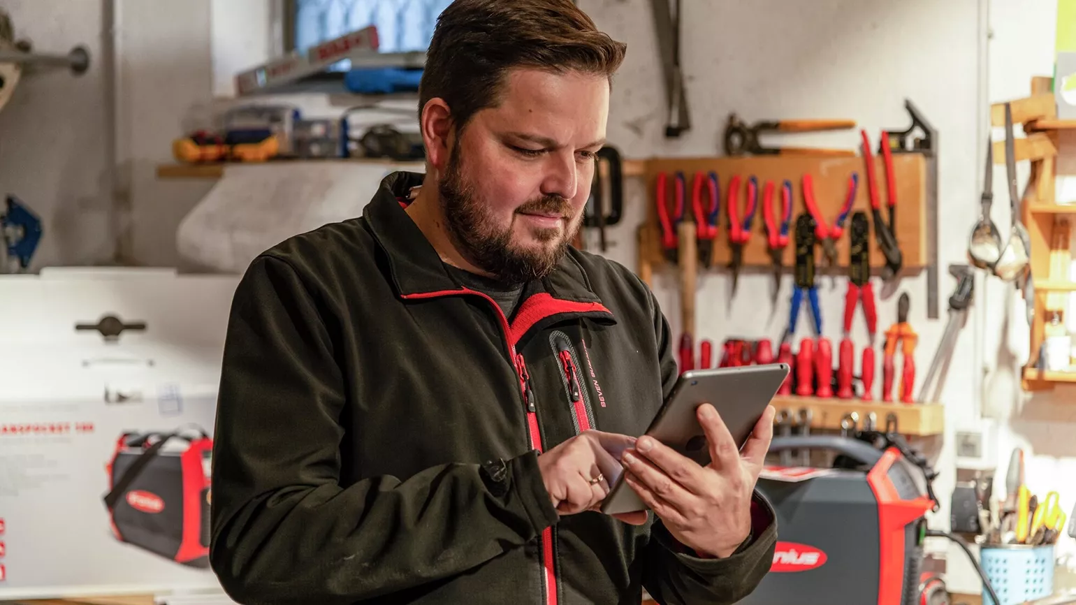 Person zuhause in der eigenen Werkstatt führt ein Webinar durch