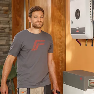 Installateur steht neben GEN24 Wechselrichter