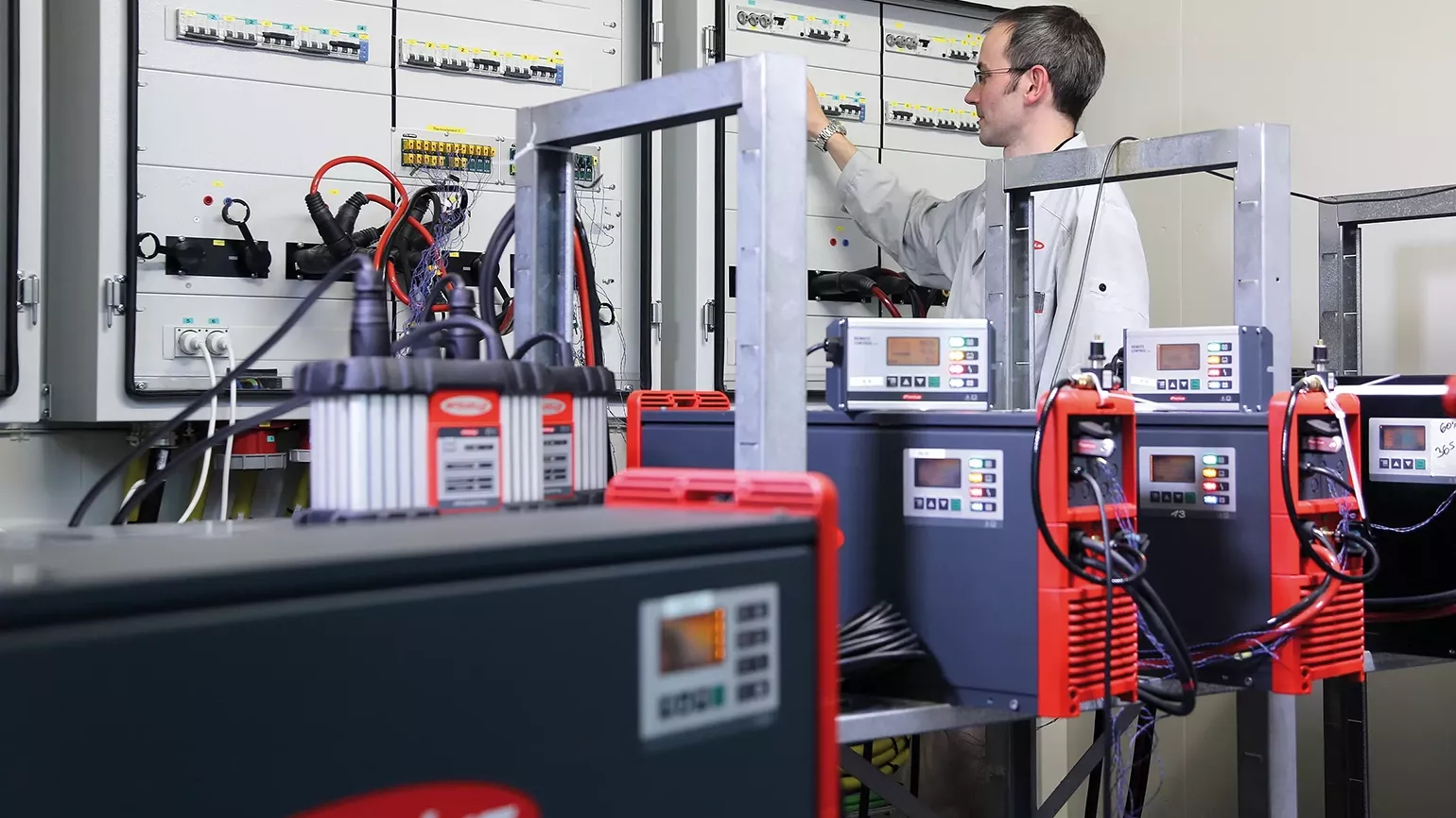 Testing the robustness of chargers in a technical lab with multiple charging devices and open control cabinets.