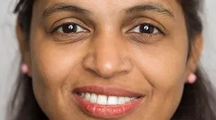 A Fronius employee smiles at the camera
