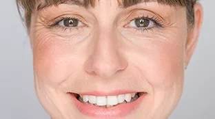 A Fronius employee is smiling in the camera.