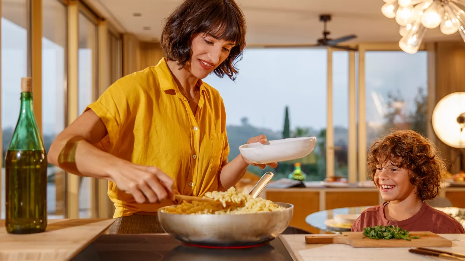 Woman and child cooking and eating in the kitchen