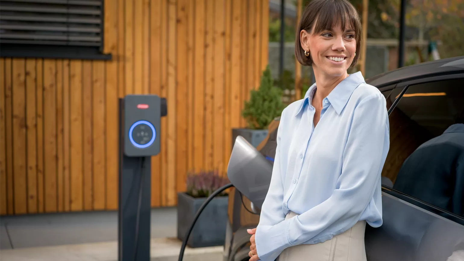 Woman with electric car and Fronius Wattpilot Flex
