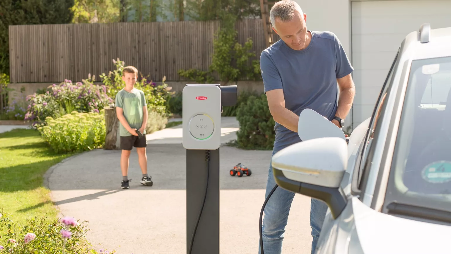 Man at home with a child using a Fronius Wattpilot Flex