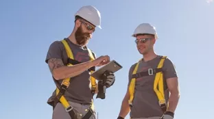 Zwei Installateure verwenden Tablets für die Konfiguration des Wechselrichters