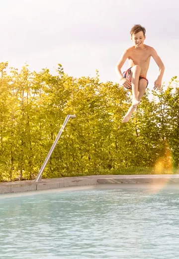 Boy jumping into a pool