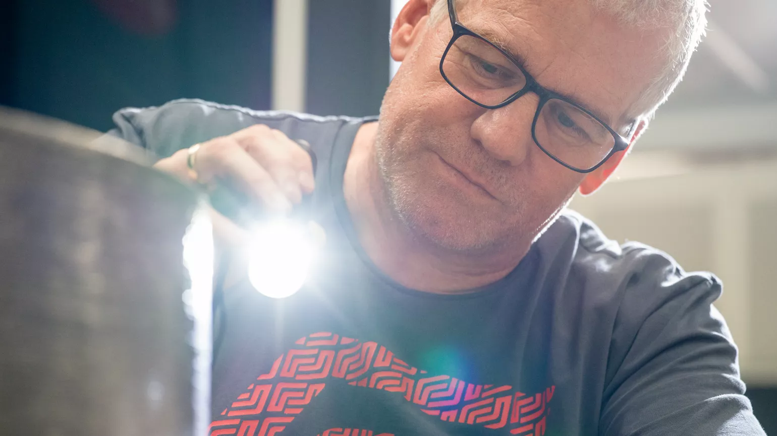 Man using flashlight to check surface