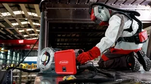 Welder adjusts settings on a welding machine.