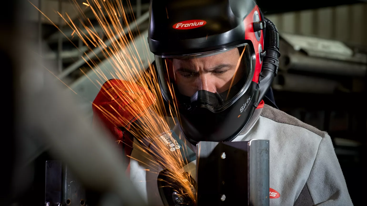 Welder grinding steel with Sirix Professional welding helmet