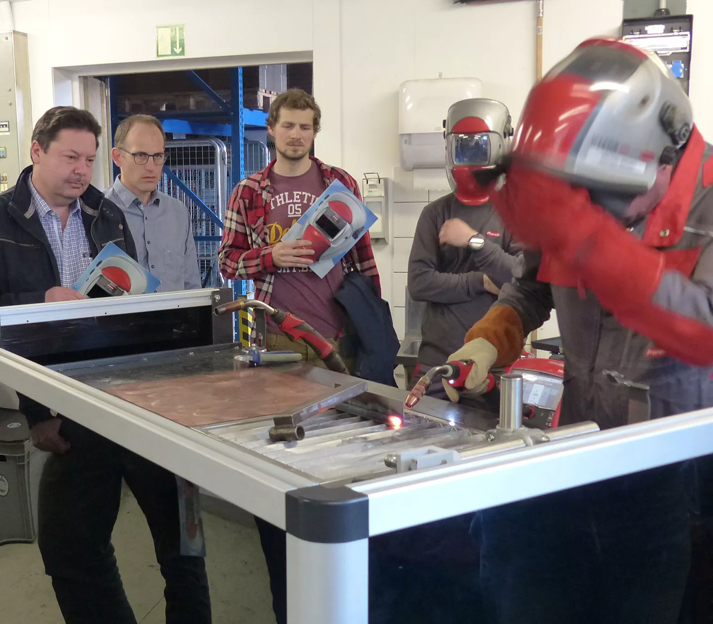 Die Veranstaltungsbesucher schauen einem Anwendungstechniker von Fronius Schweiz beim Schweissen zu
